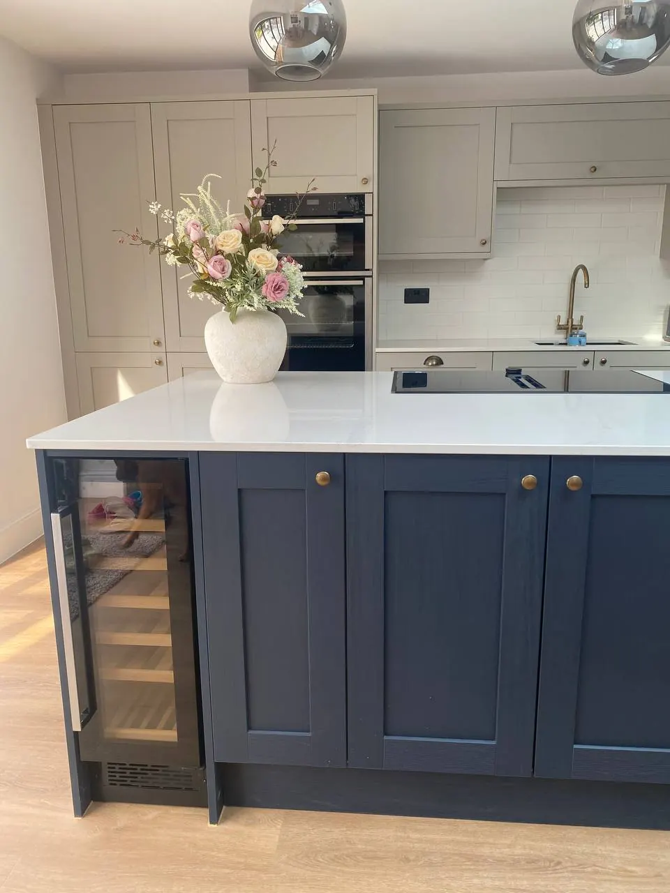 Navy island with a built-in wine cooler and aged-brass cup handles