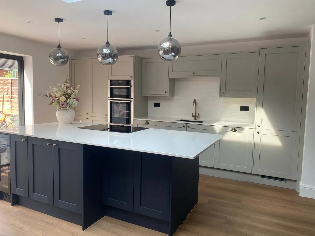 Two-tone Shaker kitchen with navy island and greige perimeter units, fitted in Leyland